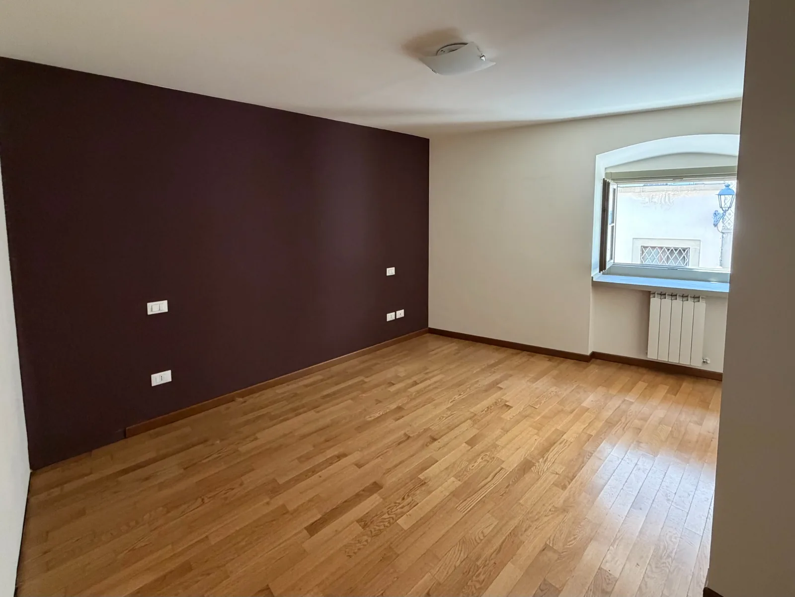 Camera matrimoniale con parquet e finestra su Via Tasso